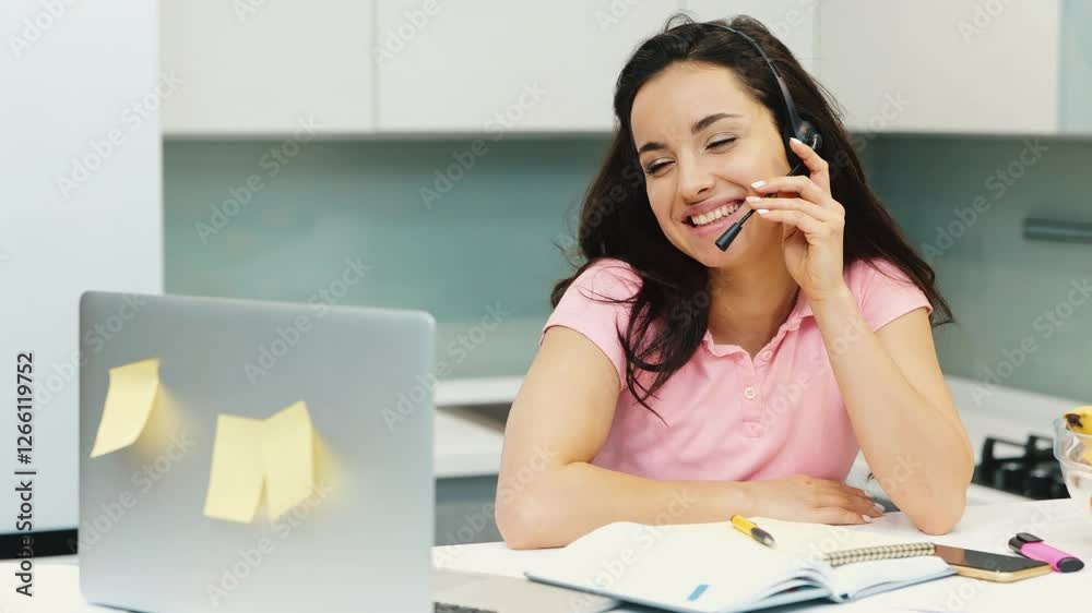 Young woman work at home during quarantine. Call center help desk manager operator talking with smile during vodeo conference. Lovely multitasking employee. Young woman work at home during quarantine. Call center help desk manager operator talking with smile during vodeo conference. Lovely multitasking employee.