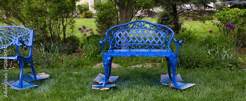 The cobalt blue bench stands freshly transformed, its surface gleaming with a fresh smooth coat of glossy spray paint, inviting visitors to sit and admire the beauty of the vibrant flowers in garden.