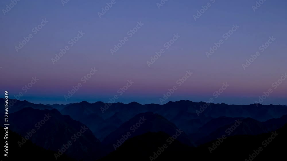 Mountain range silhouette at dusk with vibrant sky, serene landscape concept Mountain range silhouette at dusk with vibrant sky, serene landscape concept