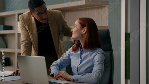 African American man mentor business coach helping Caucasian woman with laptop work explain computer project training new employee in office corporate creative teamwork businessman and worker smiling