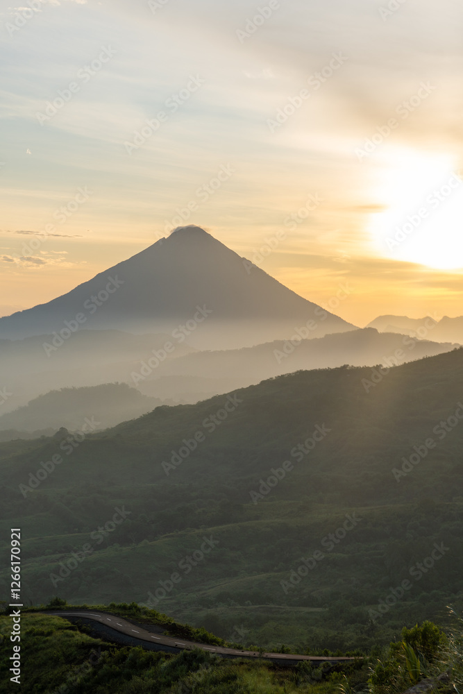 A majestic volcano stands tall at sunrise, surrounded by misty mountain layers, creating a breathtaking view. A majestic volcano stands tall at sunrise, surrounded by misty mountain layers, creating a breathtaking view.