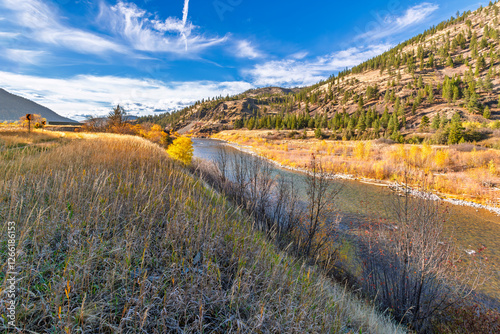 Fototapeta Naklejka Na Ścianę i Meble -  Autumn view of the Clark Fork River as it runs alongside the highway through the Missoula region near Lolo National Forest, in Western Montana, USA.	