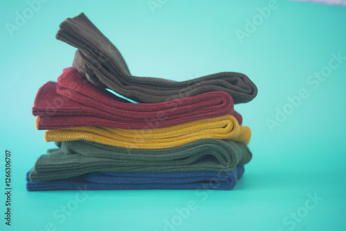 Colorful stacked socks arranged neatly on a bright background photo