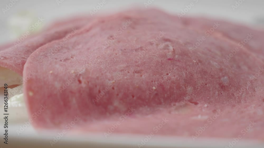 Preparing fresh sliced deli meat in a kitchen setting Preparing fresh sliced deli meat in a kitchen setting