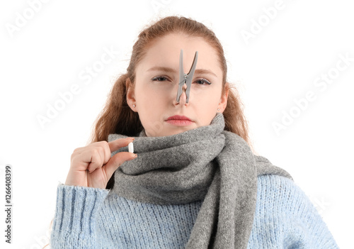 Ill young woman with clothespin on her nose and pill against white background. Stuffy nose concept