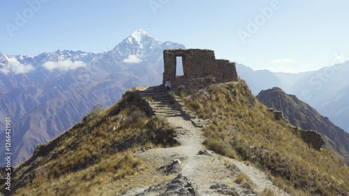 Young woman walking at the Puerta del Sol Inti Punku in the mountains of Cusco Peru