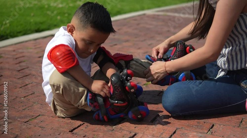 A loving mother helps her young child put on knee pads in a park. A playful, safe, and happy childhood moment filled with love, family, and outdoor fun