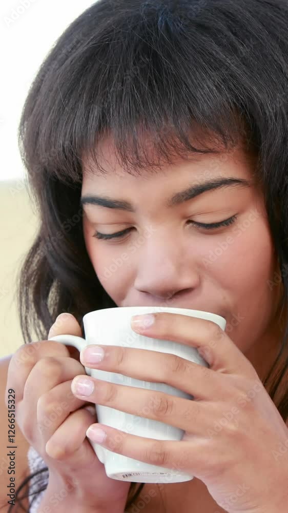 Smiling woman drinking hot beverage on bed Smiling woman drinking hot beverage on bed