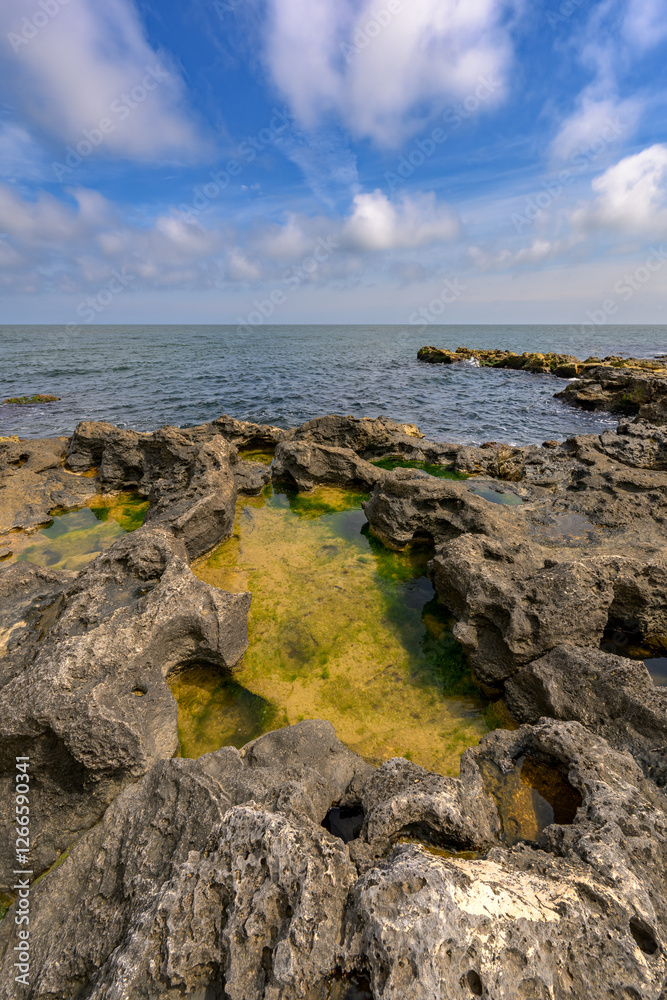 Wide angle shot of the sea and rocks with puddles in them Wide angle shot of the sea and rocks with puddles in them