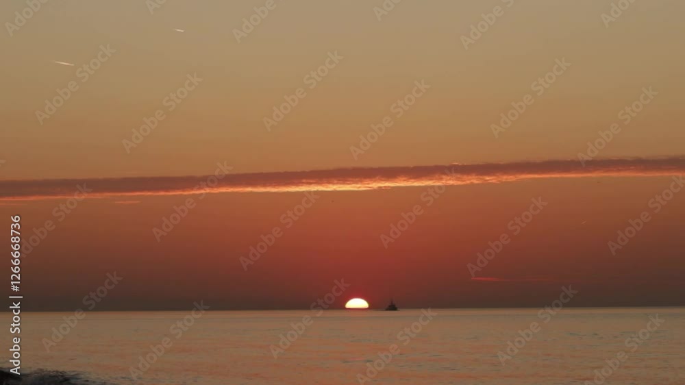 Sunset at sea with a ship, ocean backdrop and scenic waves, golden hour creates a tropical scene. Sunset at sea with a ship, ocean backdrop and scenic waves, golden hour creates a tropical scene.