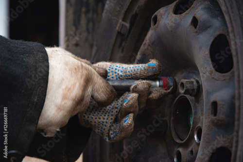 Changing a wheel. Close-up of loosening and tightening wheel bolts. Seasonal tire change. Part of the photo is blurred. The process of changing a car wheel. Close-up.