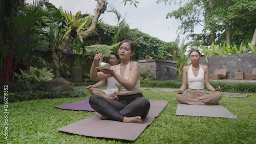 Sound Healing with Singing Bowl Meditation Yoga Pose Movement On Beautiful Lush Garden Green Grass in Ubud Bali Indonesia