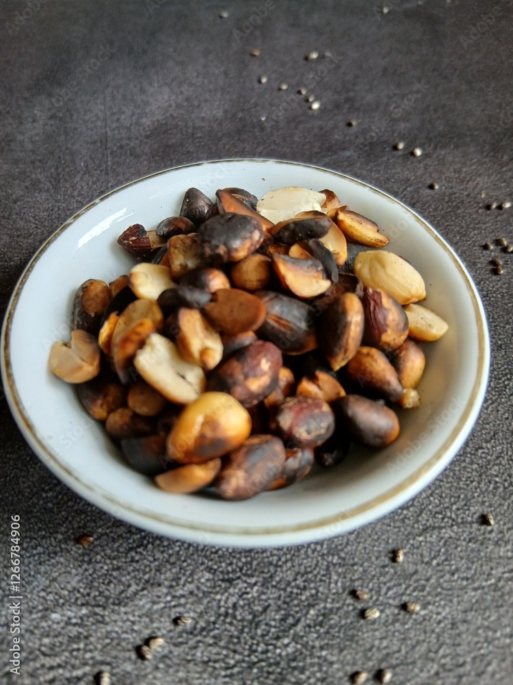 Bowl of burnt Roasted Nuts on Gray Background Bowl of burnt Roasted Nuts on Gray Background