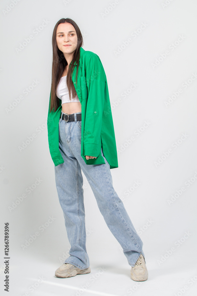 Cute young girl in green shirt and blue jeans posing on a white background Cute young girl in green shirt and blue jeans posing on a white background