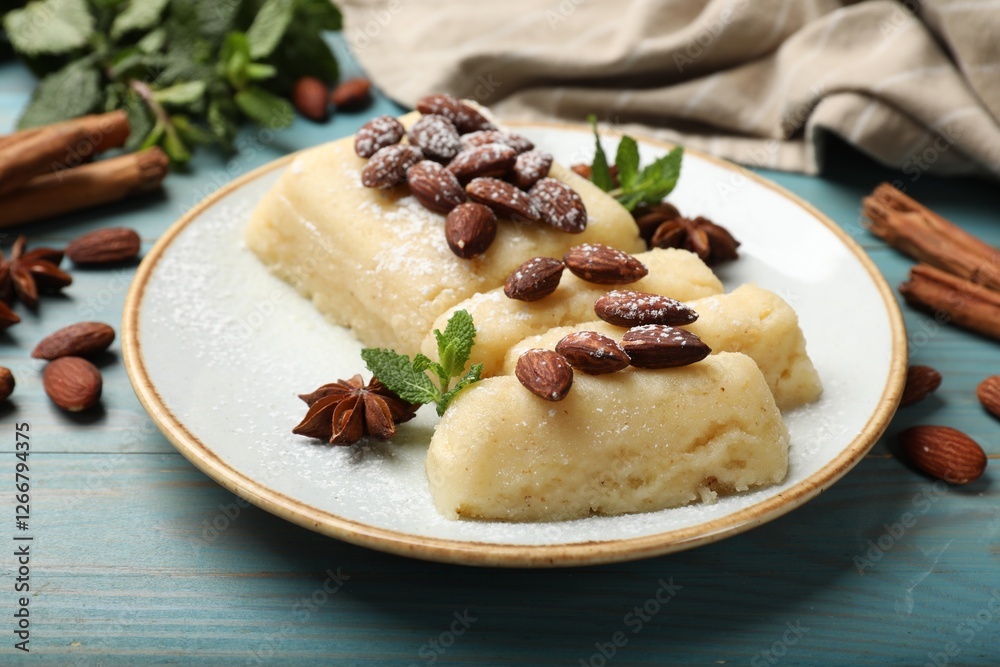Delicious sweet semolina halva with almonds, spices and mint on light blue wooden table, closeup Delicious sweet semolina halva with almonds, spices and mint on light blue wooden table, closeup