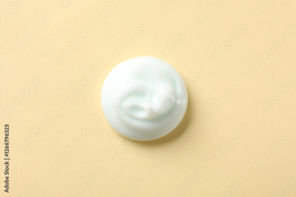 Sample of body cream on beige background, top view