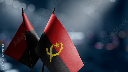 A small Angola flag on an abstract blurry background photo