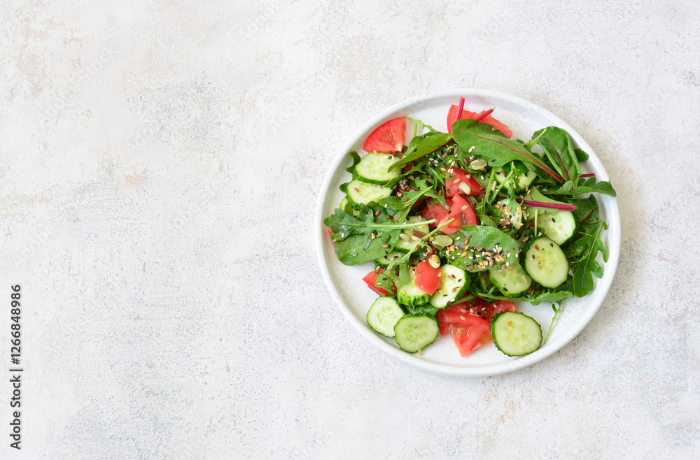Fresh Summer Salad with greenery, tomato and cucumber slices top view Fresh Summer Salad with greenery, tomato and cucumber slices top view