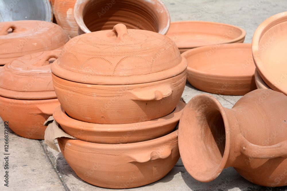Stacks of various terracotta pots for sale at a garden store. Rustic handmade ceramic clay brown terracotta cups souvenirs at street handicraft market Stacks of various terracotta pots for sale at a garden store. Rustic handmade ceramic clay brown terracotta cups souvenirs at street handicraft market
