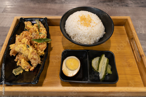 Salted egg chicken rice. It combines the rich, umami-packed taste of salted egg with crispy fried chicken, served over aromatic rice and side dishes.