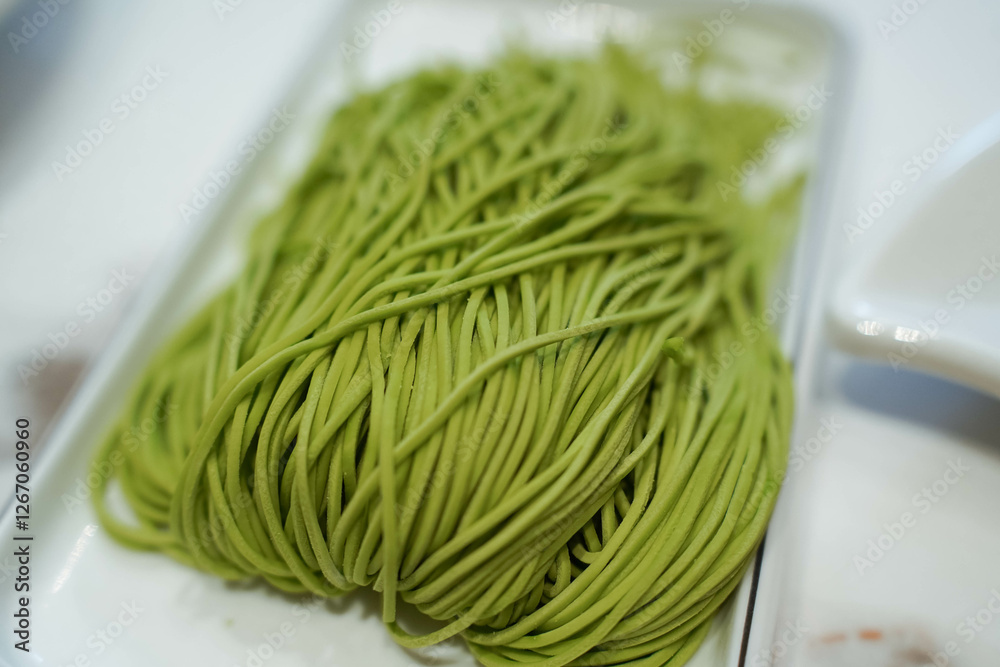 green spinach noodles in a white plate