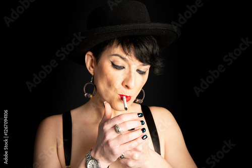 A young and beautiful woman lights a cigarette