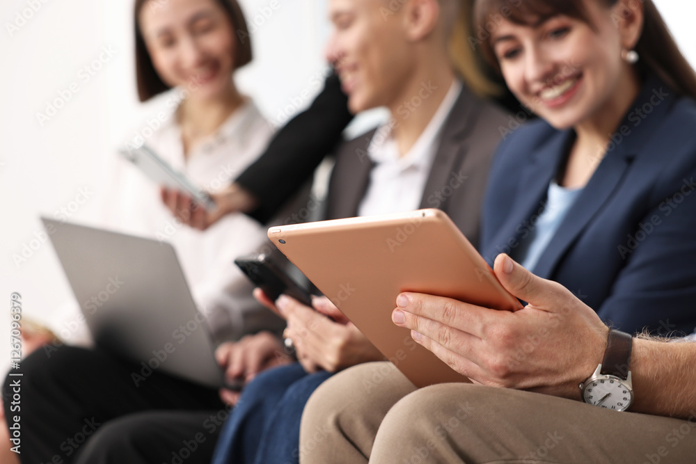 Group of people using different gadgets indoors, selective focus. Modern technology Group of people using different gadgets indoors, selective focus. Modern technology