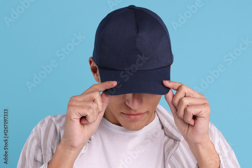 Photography Man in stylish baseball cap on light blue background