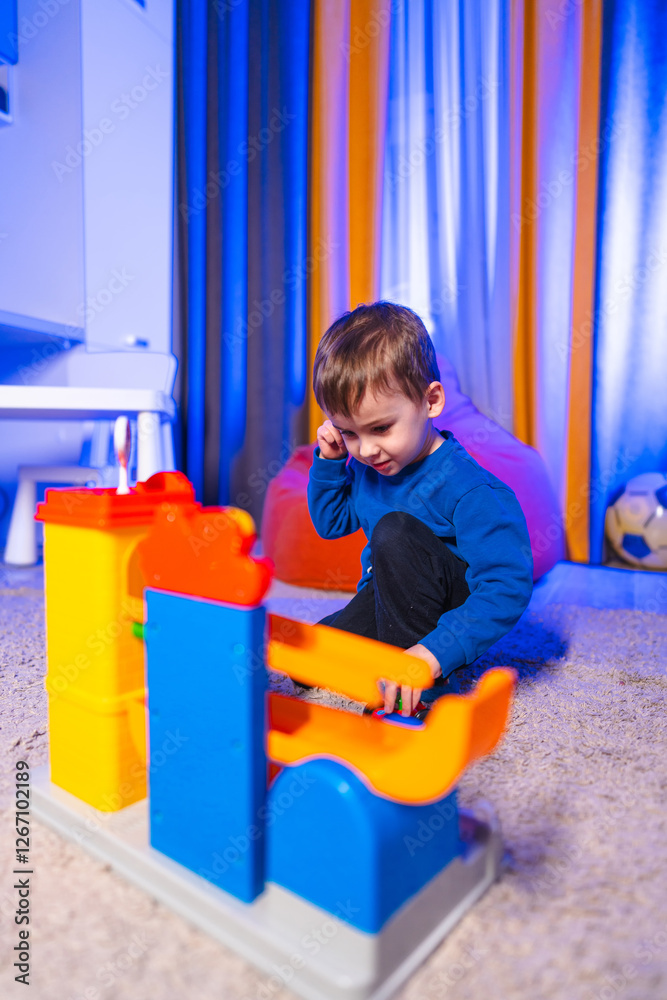 Boy playing with vibrant blocks. A small child engages creatively with vibrant building blocks in a cozy indoor space filled with soft lighting. Boy playing with vibrant blocks. A small child engages creatively with vibrant building blocks in a cozy indoor space filled with soft lighting.