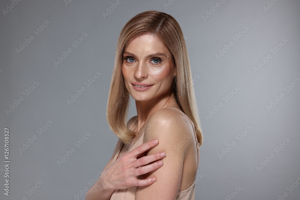 Obraz premium Portrait of beautiful woman with straight blonde hair on grey background