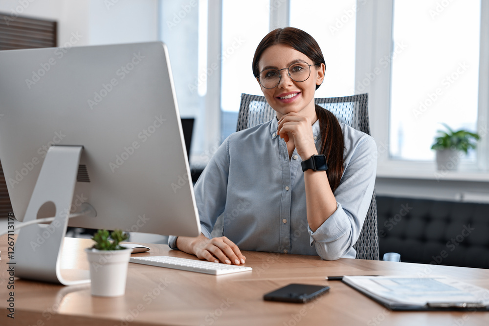 Portrait of woman at table with computer in office Portrait of woman at table with computer in office
