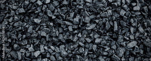 Black volcanic stone. Surface of basalt or granite close-up. Dark rough and textured rock.