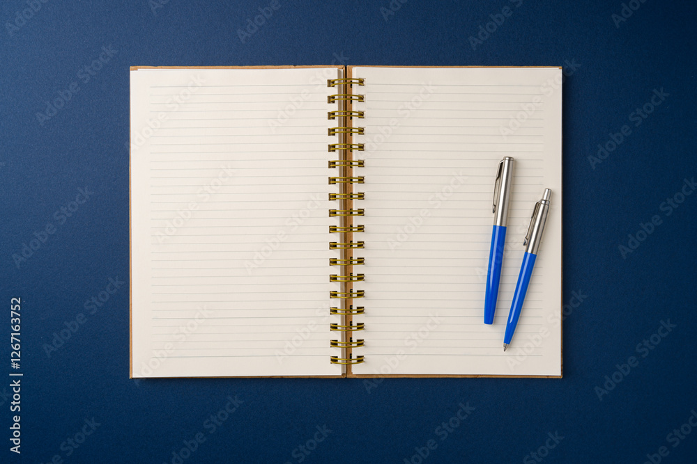 Top view of notebook and ballpoint pen on blue background Top view of notebook and ballpoint pen on blue background