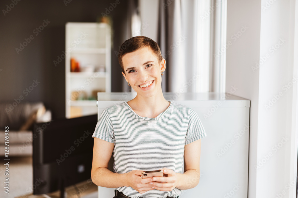 Young Woman Holding Smartphone in Modern Home Young Woman Holding Smartphone in Modern Home