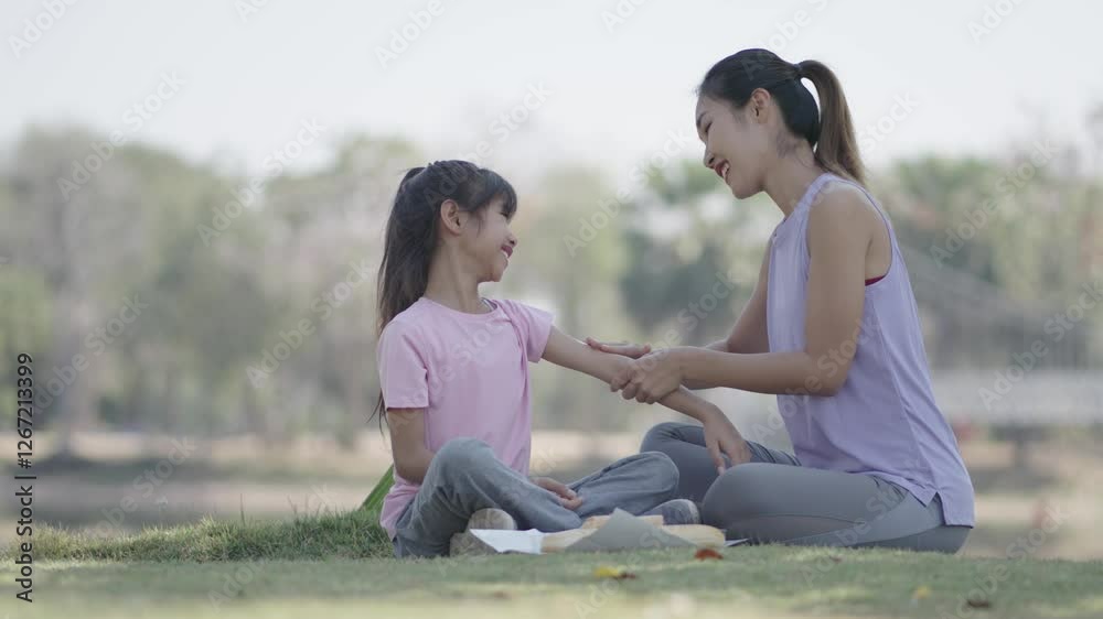Mother and daughter are applying sunscreen lotion in the park. Mother and daughter are applying sunscreen lotion in the park.