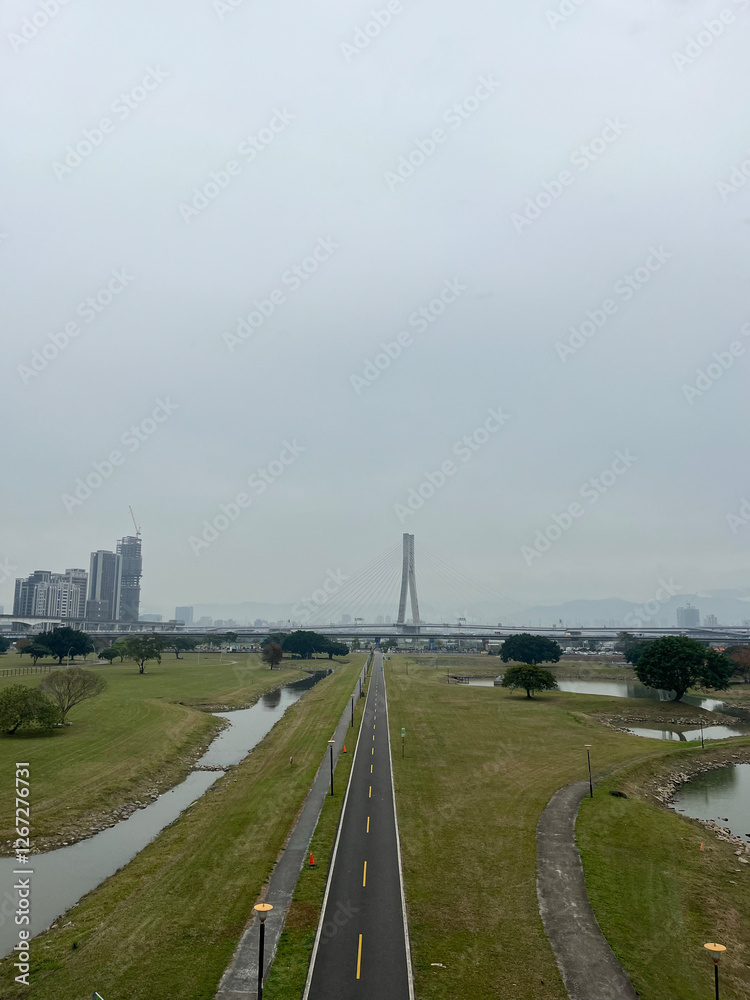 Fototapeta premium Urban landscape photography scenic view of modern bridge over waterway city park cloudy day aerial perspective nature meets architecture