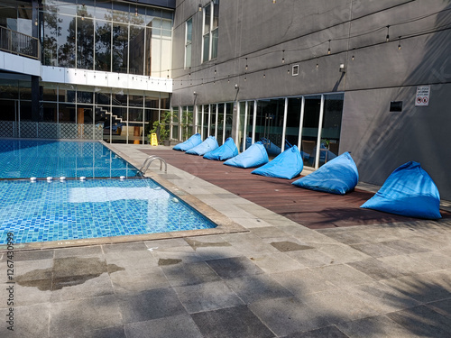 Modern Poolside Relaxation Scene Under Sunny Skies with Bean Bags