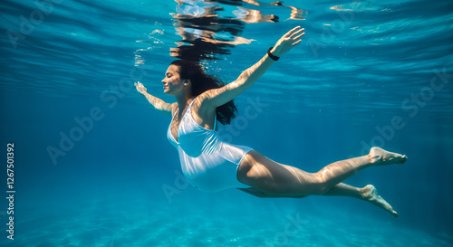 Pregnant Woman in White One-Piece Swimsuit Swimming Underwater - Concept of Water Health and Birth
