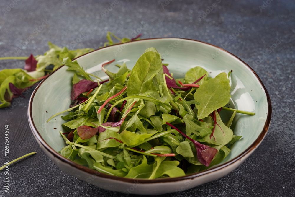 Healthy salad leaves mix in a  over dark  stone or concrete background