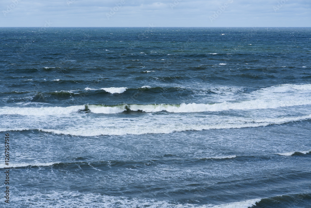 Stormy waves of the Baltic Sea with white crests off the coast of Estonia. Cloudy sky, dramatic landscape. Stormy waves of the Baltic Sea with white crests off the coast of Estonia. Cloudy sky, dramatic landscape.