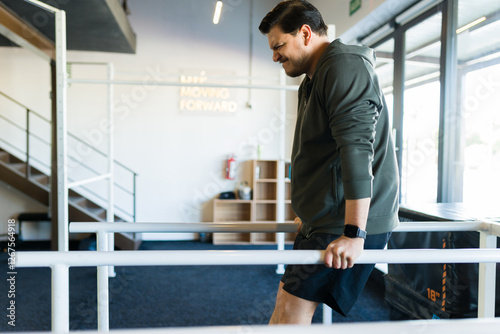 Hispanic man executing dips on parallel bars, demonstrating strength training and physical fitness commitment