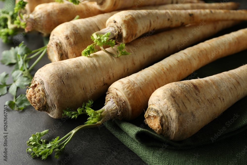 Parsley roots with leaves on black table, closeup Parsley roots with leaves on black table, closeup