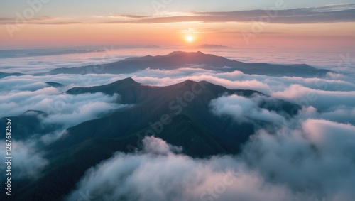 Captivating Sunrise Over Mountain Peaks Surrounded By Misty Clouds In A Tranquil Aerial Landscape Perfect For Nature Photography.