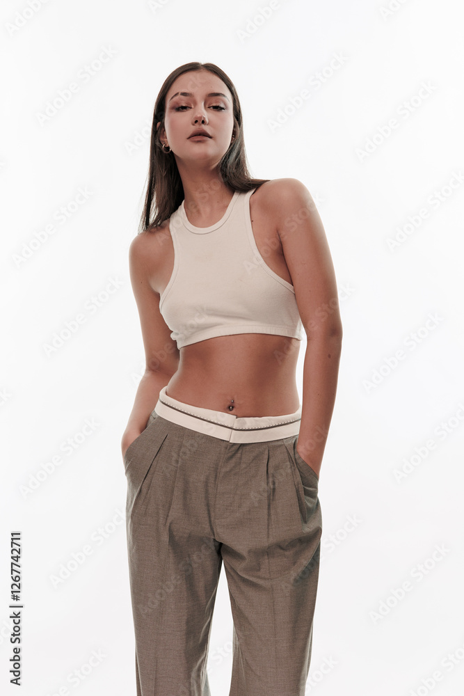 Young girl in trousers posing on a white background Young girl in trousers posing on a white background