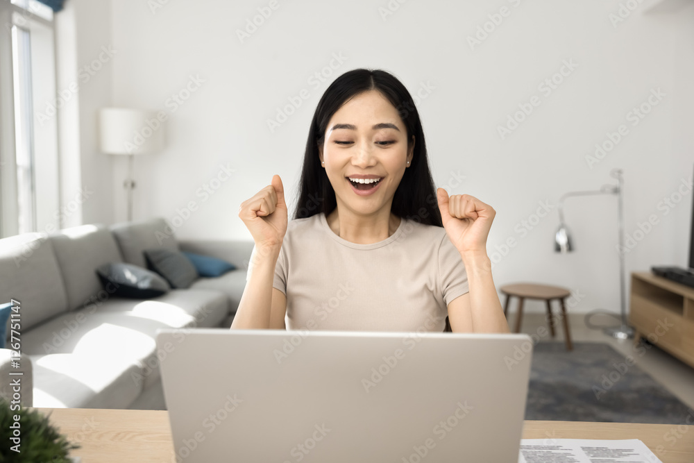 Happy young Asian woman reading e-mail with great, unbelievable news, receiving job offer or promotion, academic success, positive financial or business outcome, bank mortgage approval, lottery win Happy young Asian woman reading e-mail with great, unbelievable news, receiving job offer or promotion, academic success, positive financial or business outcome, bank mortgage approval, lottery win
