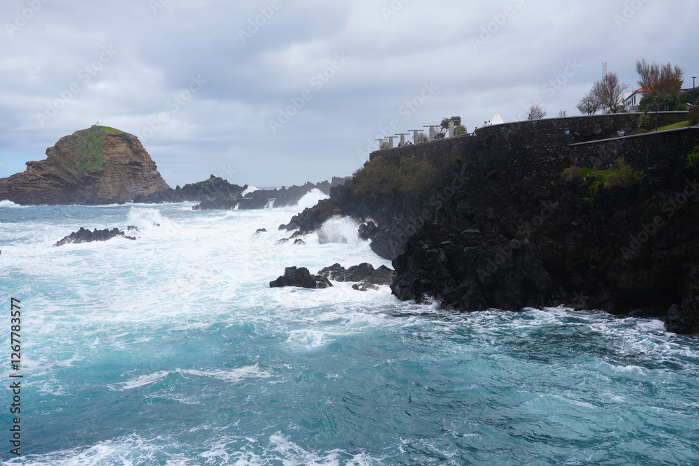 Die wunderschöne Küste in Porto Moniz auf Madeira mit hohen Wellen und einer Gischt die sich über den Felsformationen im Ozean bildet Die wunderschöne Küste in Porto Moniz auf Madeira mit hohen Wellen und einer Gischt die sich über den Felsformationen im Ozean bildet
