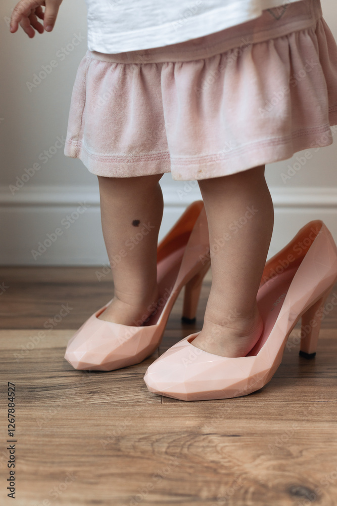 baby girl putting on her mother's shoes baby girl putting on her mother's shoes