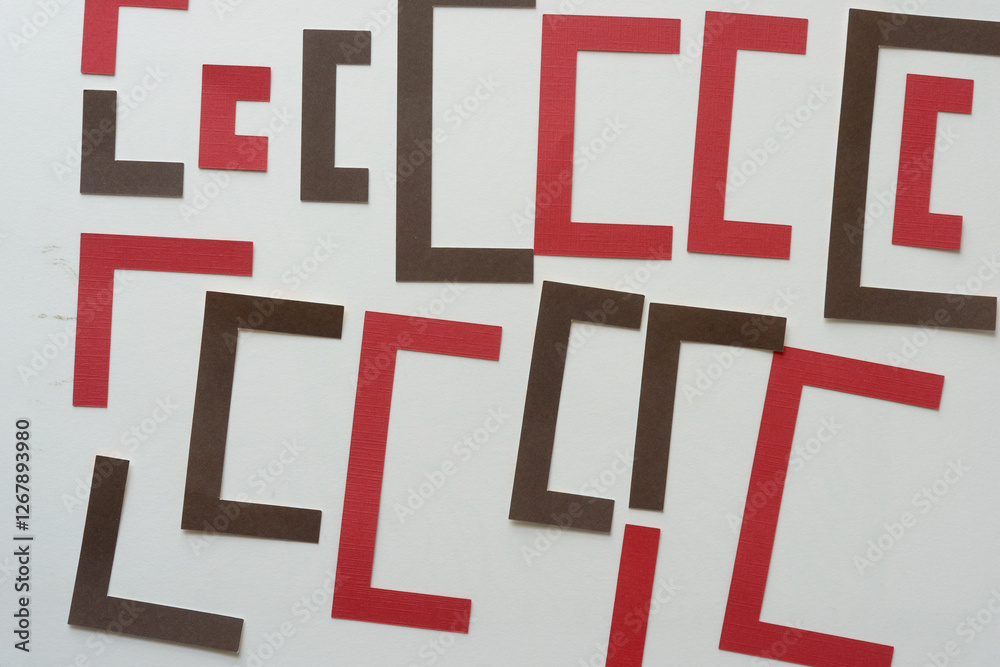 red and brown paper shapes arranged on blank paper
