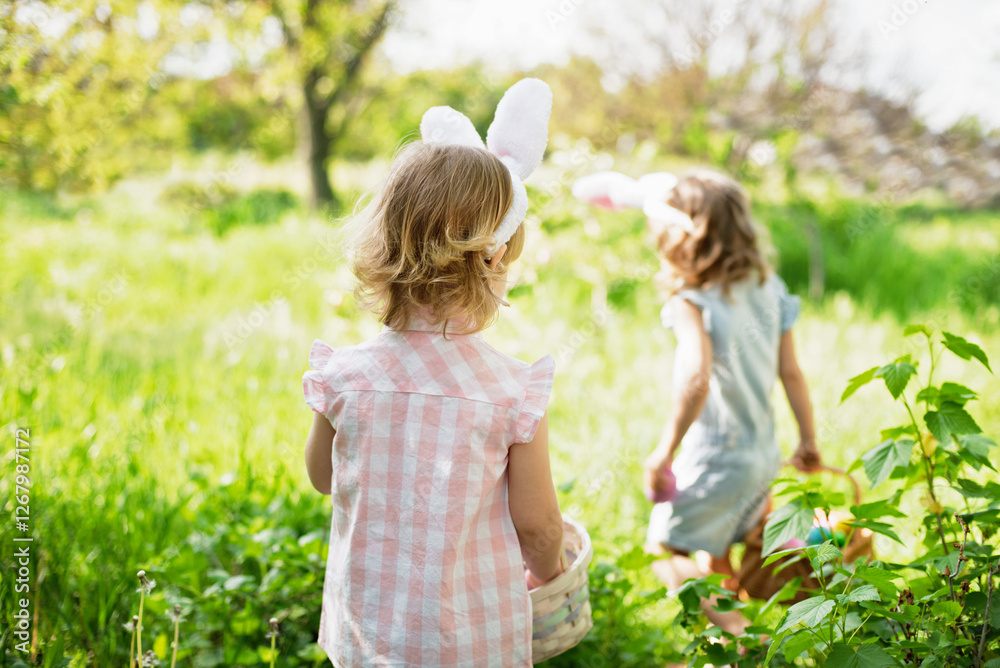 Fototapeta premium Easter egg hunt. Group Of Children Wearing Bunny Ears Running To Pick Up colorful Egg On Easter Egg Hunt In Garden. Easter tradition