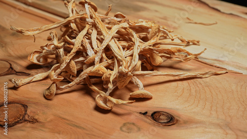 Psilocybin dry mushrooms on wood table background. Microdosing and non-traditional healing concept. Alternative medicine and self treatment from depression and PTSD. Magic mushrooms. photo